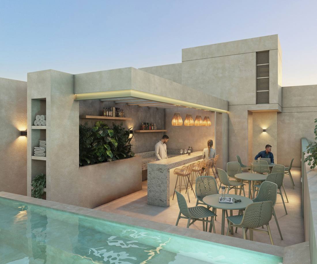 Terraza común en azotea con barra, iluminación cálida y jacuzzi.